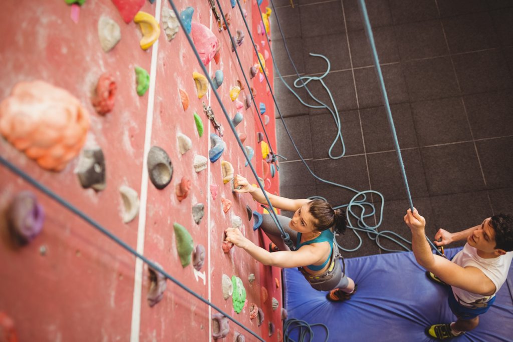 Girl climbing rock wall in recreation center
