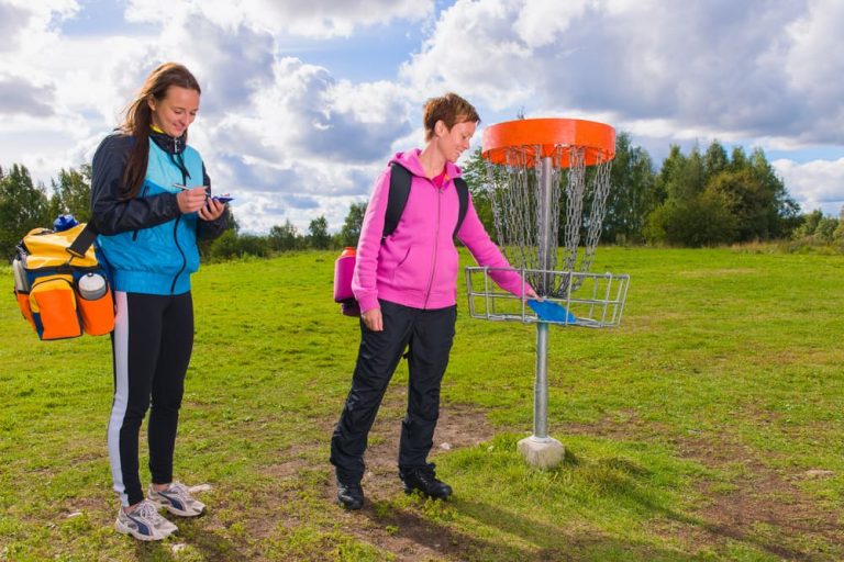 Women playing disc golf at outdoor sports complex