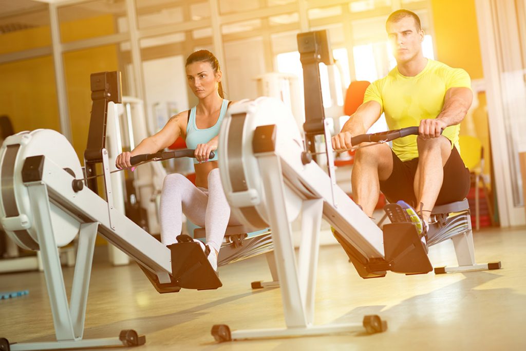 man and woman on rowing machines at a sports complex