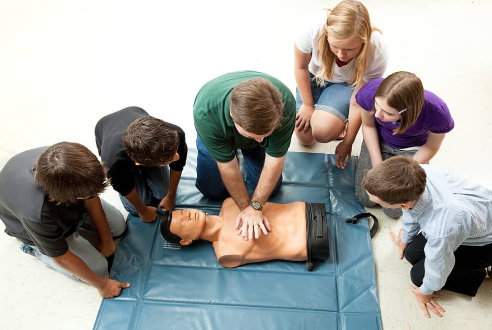 Group of people doing CPR training.