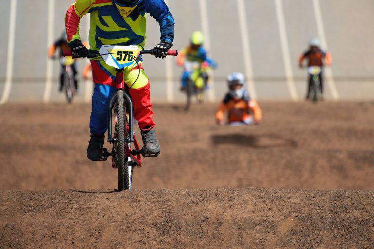 BMX Riders racing over dirt track