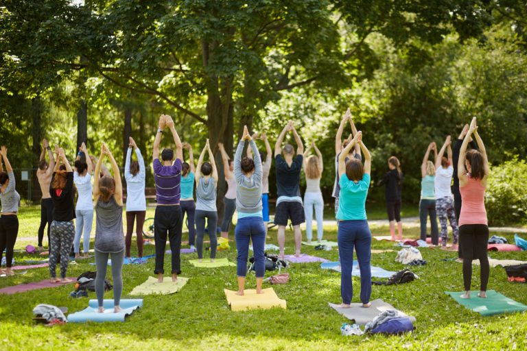 Group of people practicing yoga in a public park